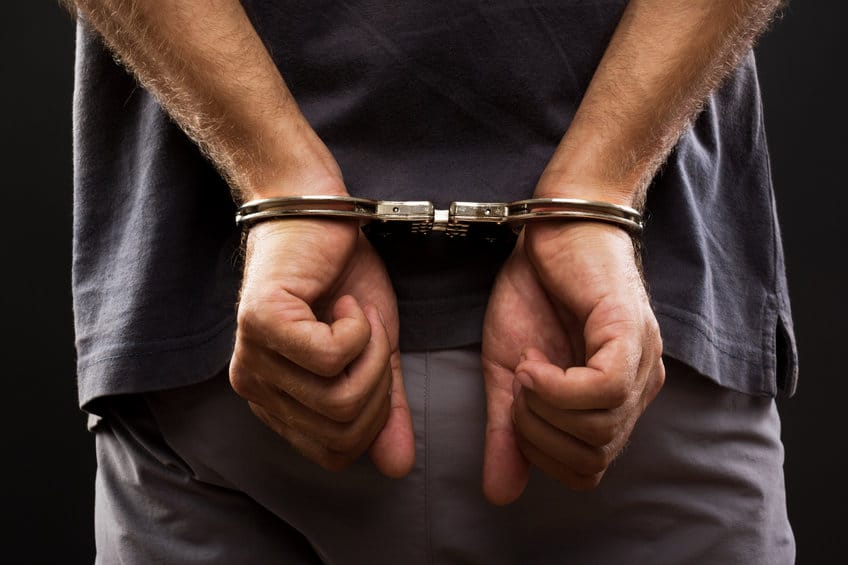 Close-up Arrested man handcuffed hands at the back